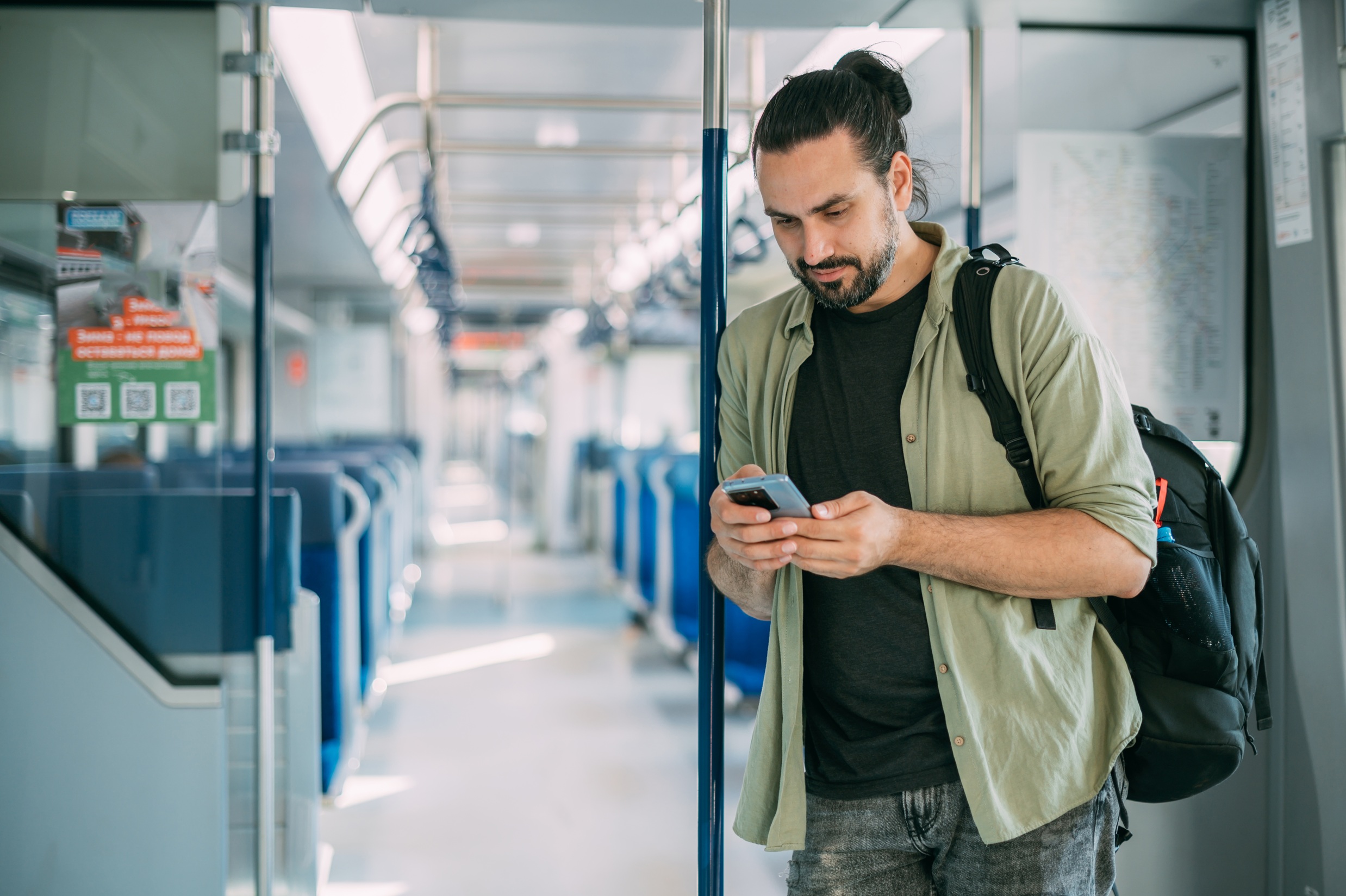 A Caucasian man with a phone rides on the train, in the skytrain, in the subway. Urban transport.