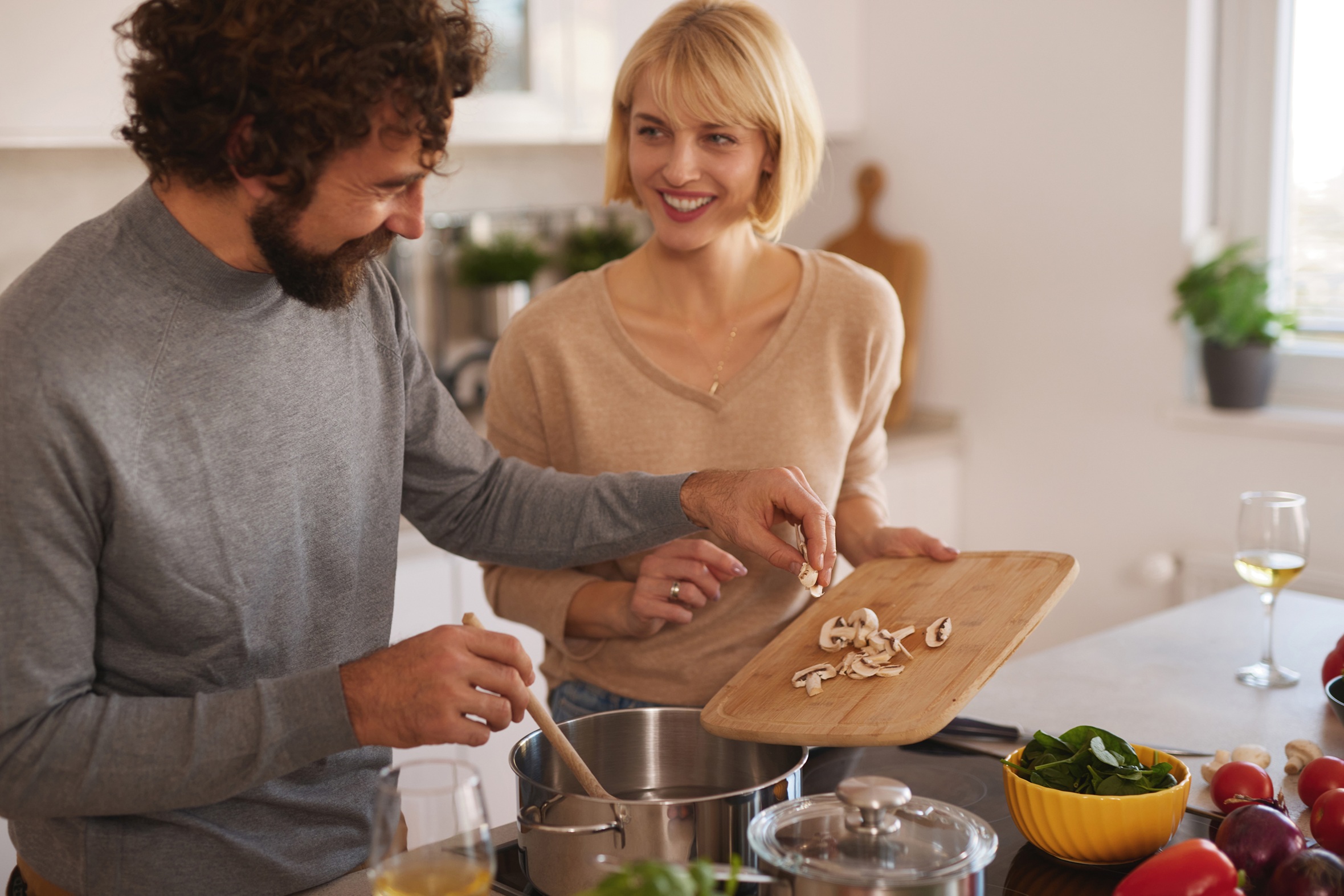 Couple enjoying cooking together in a bright kitchen while preparing a healthy meal with fresh ingredients